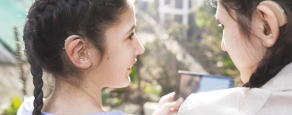 Two girls playing with smartphone