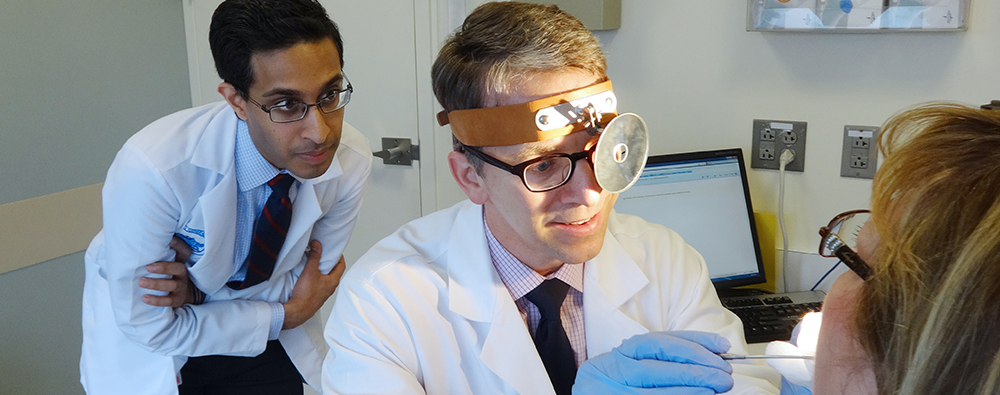 Harvard otolaryngology resident examining a patient with a physician